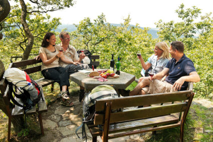 Zwei Pärchen sitzen an einem Picknick-Platz und trinken Wein im Ahrtal