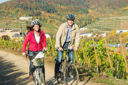 Pärchen fährt mit Fahrrädern durch die Weinberge im Ahrtal