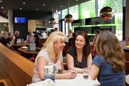 Drei Frauen sitzen in einer Bar in Attendorn und trinken Bier