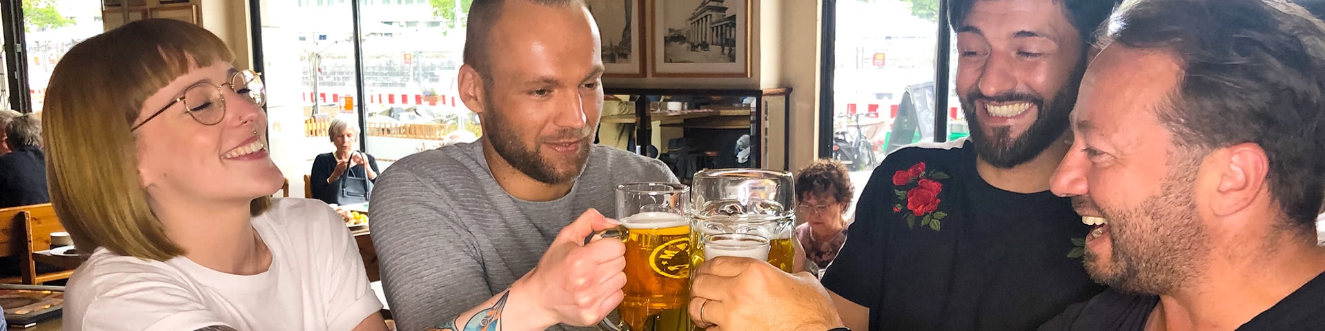 Gruppe stößt mit Bier an in der Gaststätte 