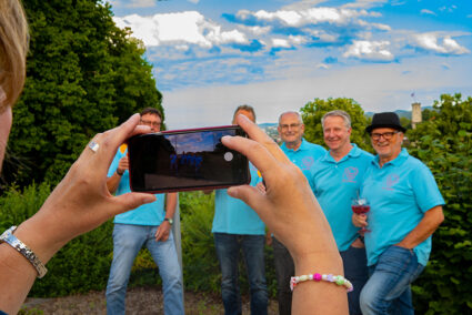 Eine Frau macht ein Gruppenfoto von einer Männergruppe in Bielefeld