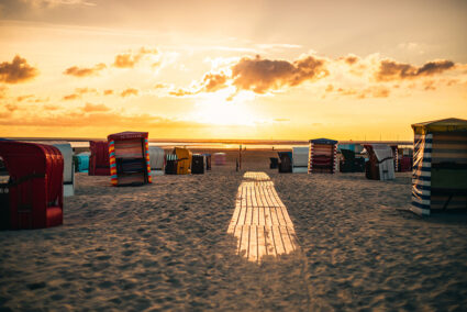 Der Strand von Borkum mit vielen bunten Strandkörben bei Sonnenuntergang