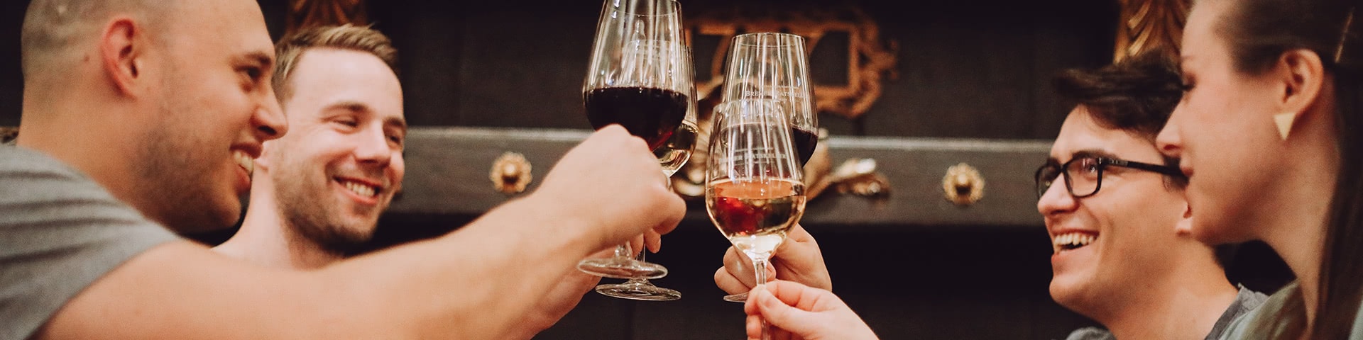 Eine Gruppe stößt mit einem Glas Wein an im Ratskeller in Bremen