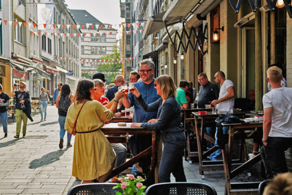 Gruppe stößt geminsam mit einem Altbier an in der Altstadt von Düsseldorf