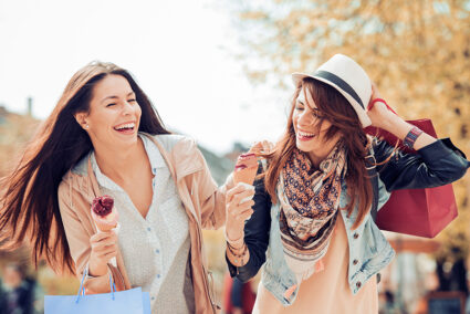 Zwei Freundinnen essen auf gemeinsamer Shopping-Tour durch Düsseldorf ein Eis