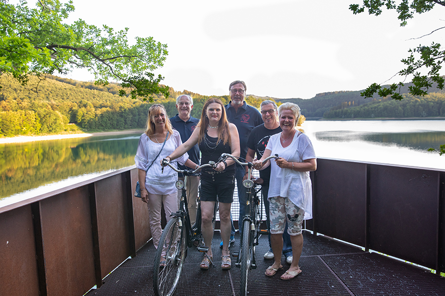 Gruppe macht Pause von einer Radtour an einer Aussichtsplattform am Hennesee