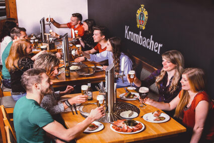 Gemeinsames Essen mit eingebauter Zapfanlage am Tisch in der Krombacher Erlebniswelt