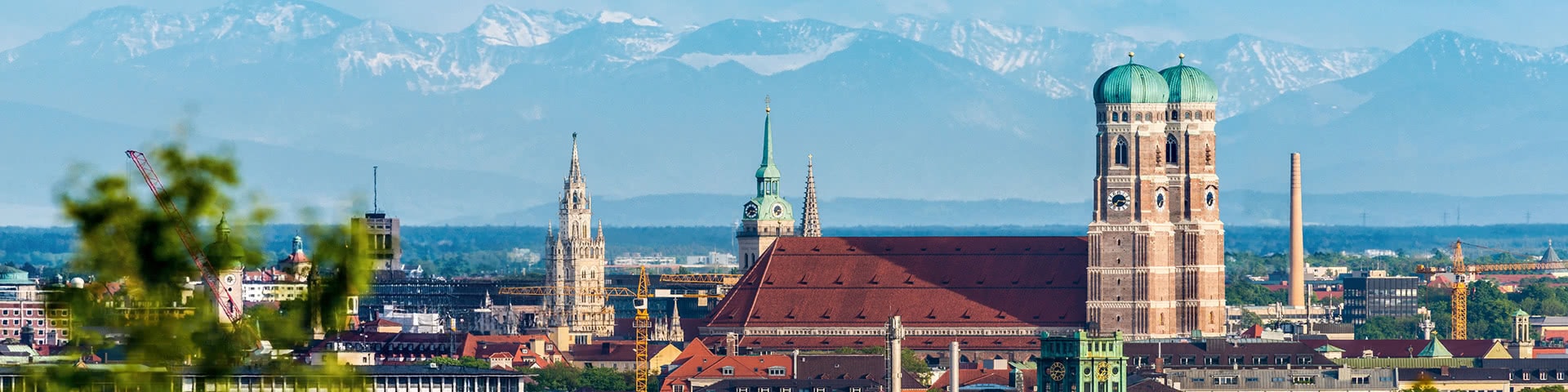 Frauenkirche in München vor Alpenpanorama