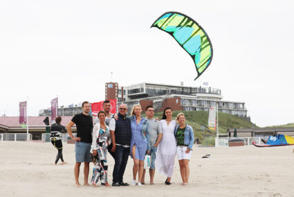 Gruppe steht am Strand von Wijk aan Zee und schaut auf das Meer