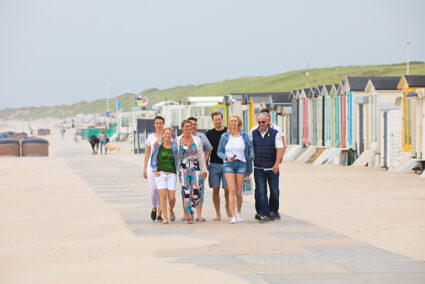 Gruppe spaziert am Strand von Wijk aan Zee entlang