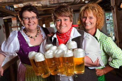 Drei Frauen in Tracht mit viel Bier im Hotel Dorf Alm in Willingen