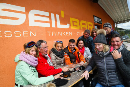 Fröhliche Gruppe sitzt an der Seilbar in Willingen